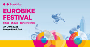 Póster del Eurobike Festival: gran texto rosa “EUROBIKE FESTIVAL”, bicicletas en movimiento, skyline de la ciudad y diseños circulares de colores sobre un fondo degradado azul.